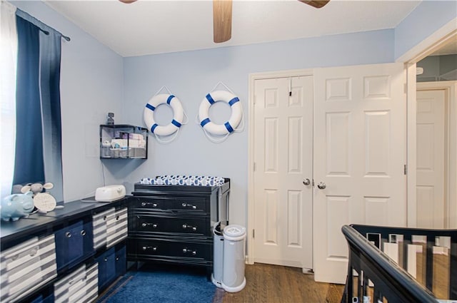 bedroom featuring dark wood-style floors, a closet, and a ceiling fan