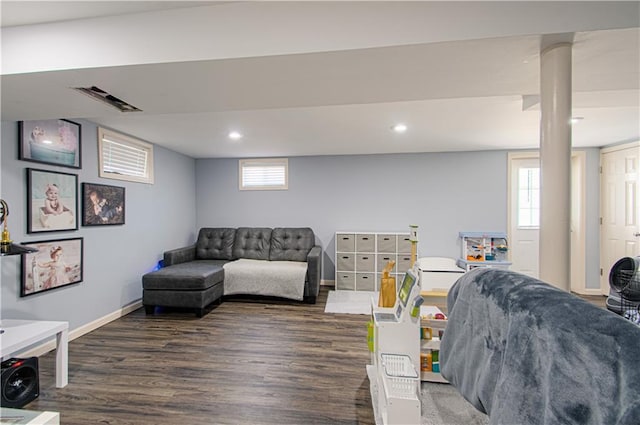 living room with visible vents, wood finished floors, a wealth of natural light, and baseboards