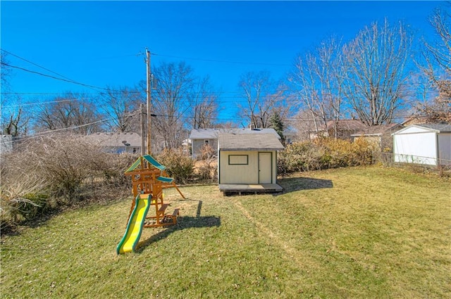 view of yard with a storage shed, a playground, and an outdoor structure