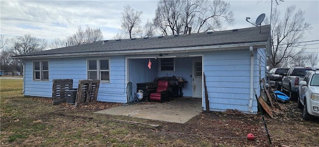 back of house featuring a shingled roof