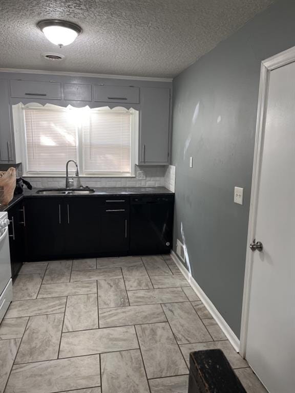 kitchen with a textured ceiling, tasteful backsplash, dark countertops, and a sink