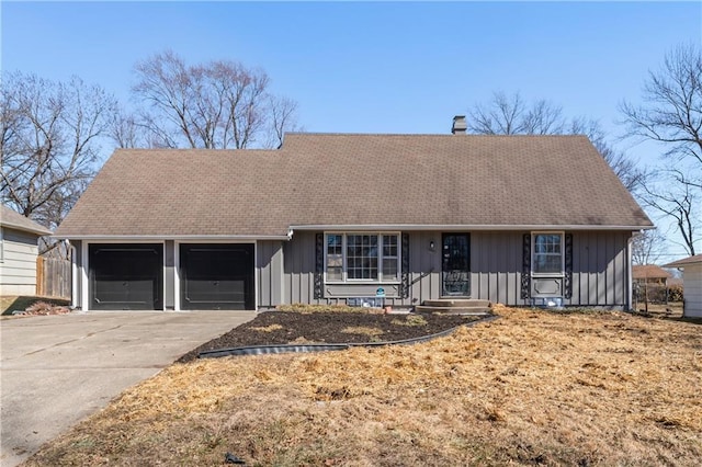 ranch-style home featuring a garage, a chimney, board and batten siding, and concrete driveway