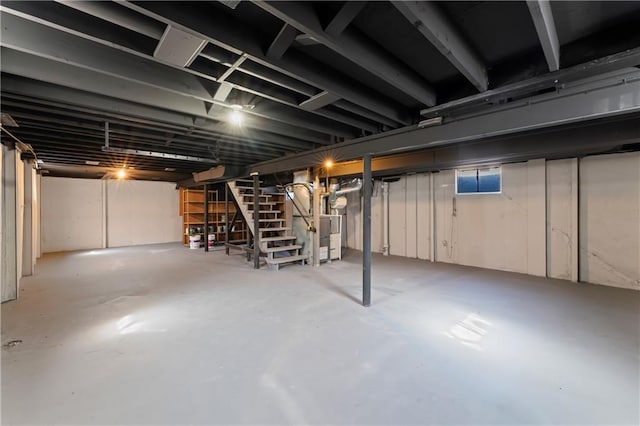 unfinished basement with heating unit and stairway