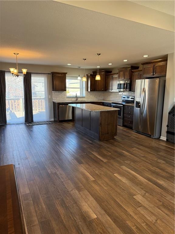 kitchen with stainless steel appliances, dark wood-type flooring, backsplash, and dark brown cabinets