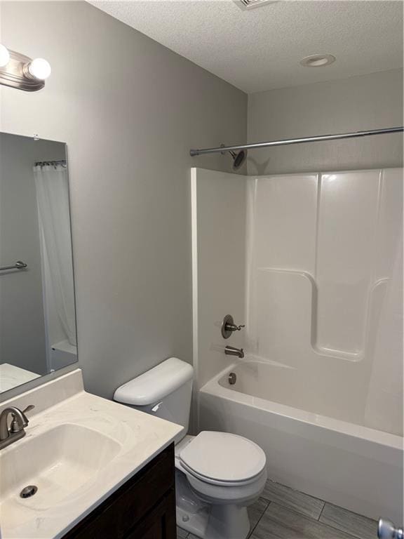 bathroom featuring a textured ceiling, toilet, wood finished floors, vanity, and shower / bath combination with curtain