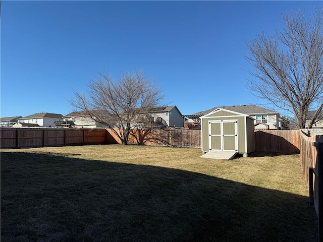 view of yard featuring a storage unit, an outdoor structure, and a fenced backyard