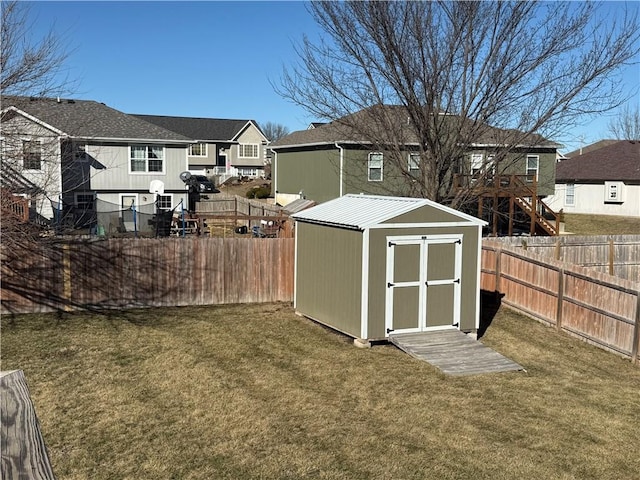 exterior space featuring a storage shed, a fenced backyard, a residential view, and an outdoor structure