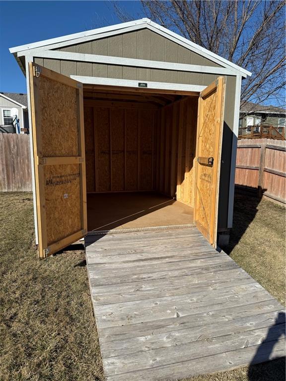 view of outbuilding featuring an outdoor structure and fence