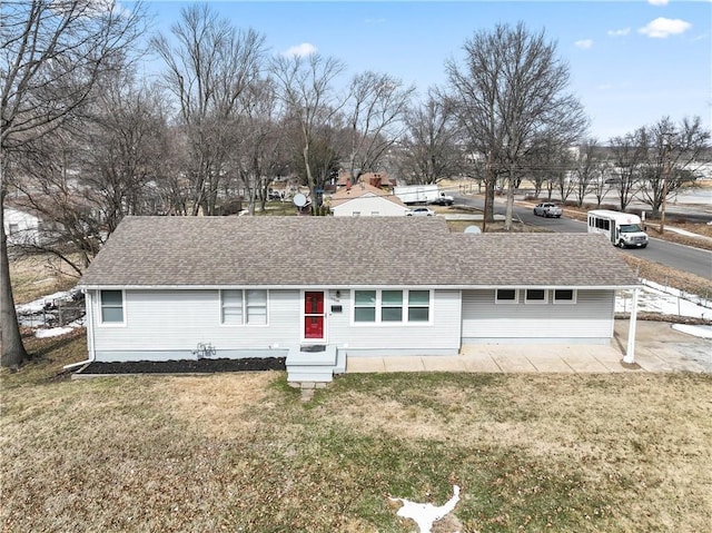 ranch-style house with a shingled roof and a front yard