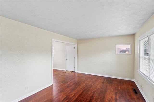 unfurnished room with visible vents, baseboards, and wood finished floors