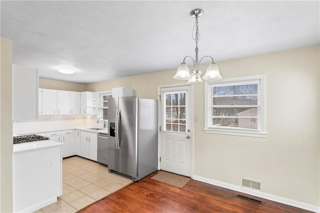 kitchen featuring visible vents, stainless steel appliances, light wood-type flooring, and light countertops