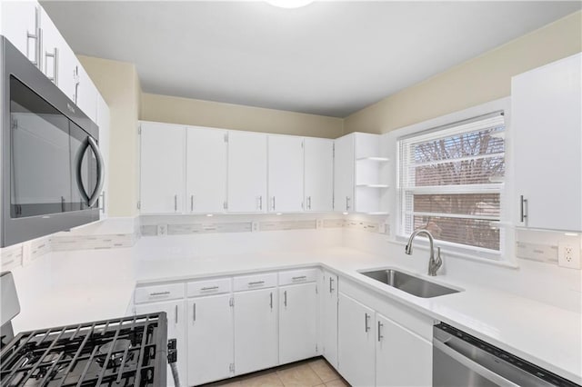 kitchen with light tile patterned floors, stainless steel appliances, light countertops, and a sink