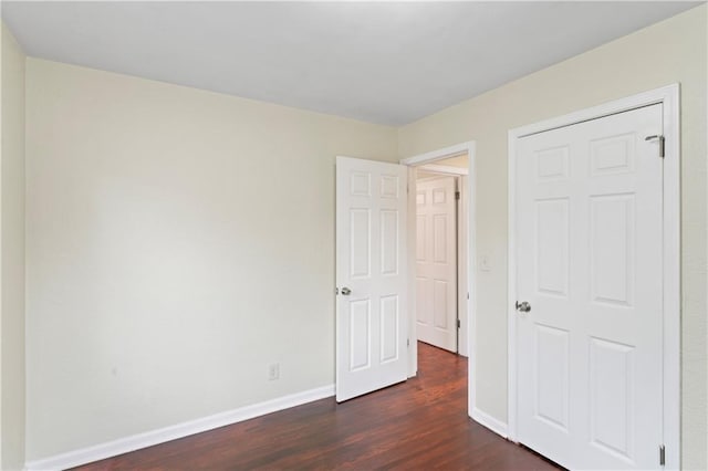 unfurnished bedroom featuring dark wood finished floors and baseboards