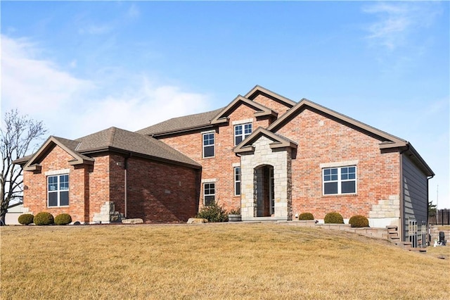 view of front facade featuring brick siding, stone siding, and a front yard