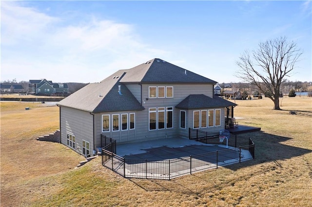 rear view of property with a patio area, a shingled roof, fence, and a yard