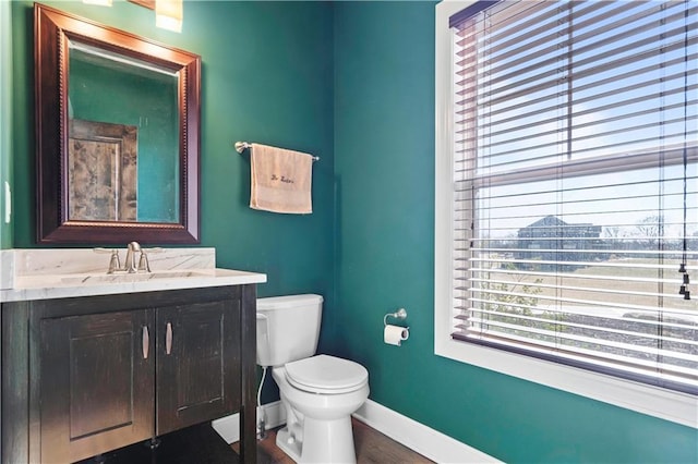 bathroom with vanity, toilet, and baseboards