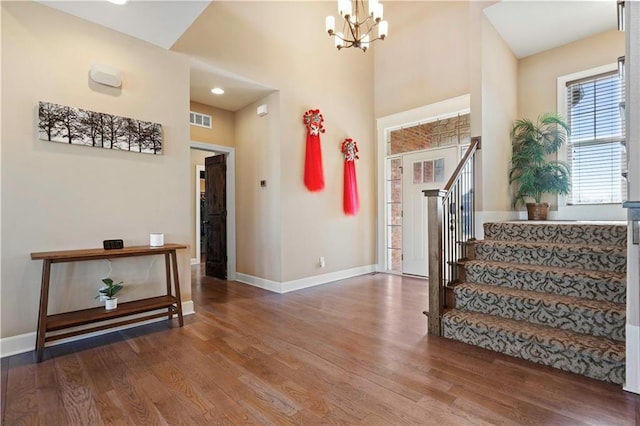 foyer entrance with stairs, baseboards, and wood finished floors