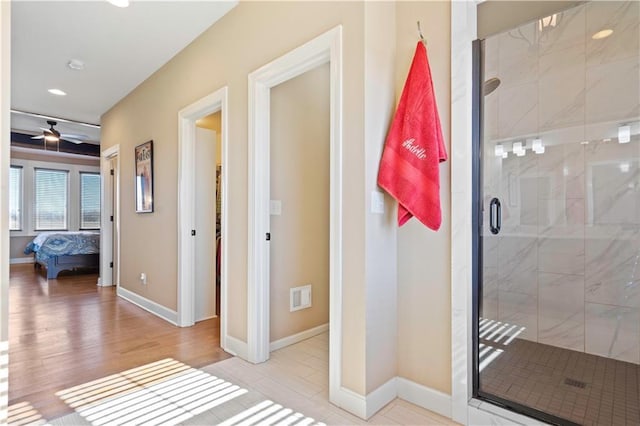 bathroom with visible vents, ensuite bathroom, a stall shower, ceiling fan, and baseboards