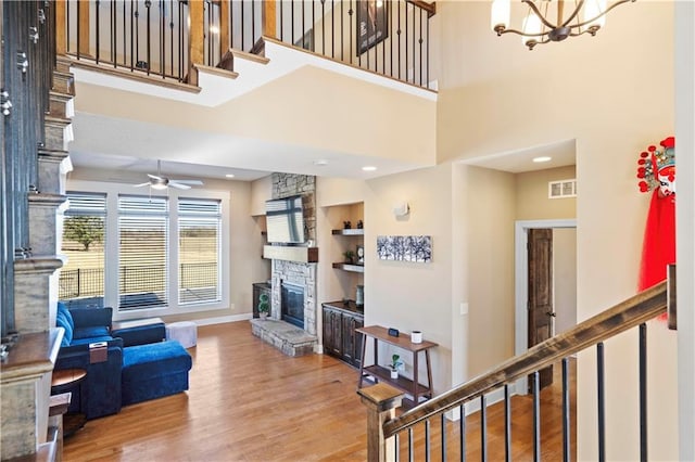 living room with visible vents, built in shelves, stairway, wood finished floors, and a fireplace