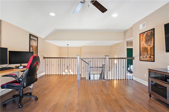 office space with lofted ceiling, baseboards, visible vents, and wood finished floors