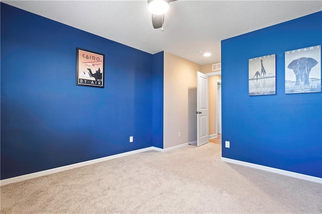 spare room featuring carpet, visible vents, ceiling fan, and baseboards