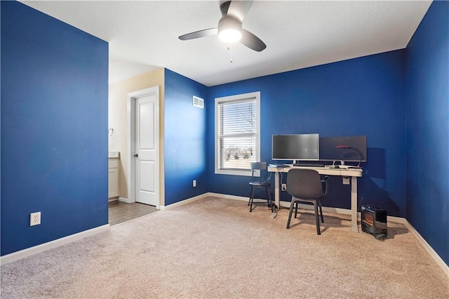 carpeted office with a ceiling fan, visible vents, and baseboards