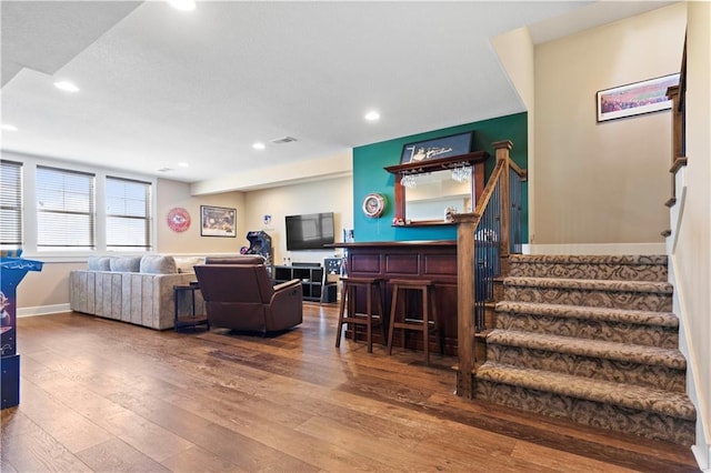 living room with hardwood / wood-style floors, stairway, a dry bar, and recessed lighting