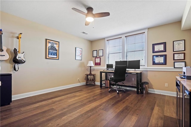 office space featuring dark wood-style floors, visible vents, baseboards, and a ceiling fan