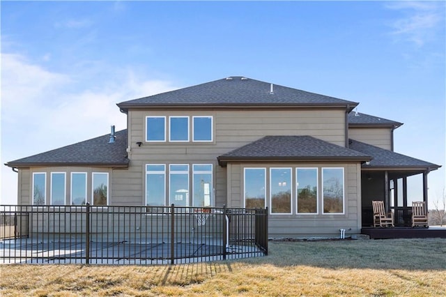 back of property featuring a patio area, roof with shingles, a yard, and fence