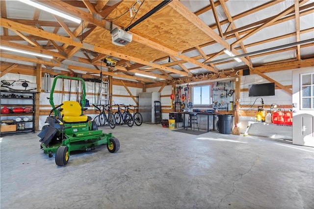 garage featuring a garage door opener and freestanding refrigerator