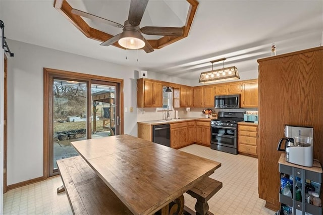 kitchen featuring range with two ovens, stainless steel microwave, a barn door, ceiling fan, and dishwasher