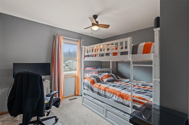 carpeted bedroom with visible vents, a ceiling fan, and baseboards