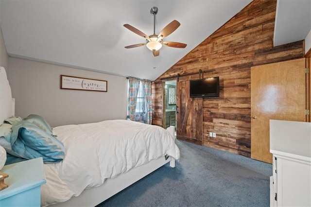 carpeted bedroom featuring lofted ceiling, a barn door, wooden walls, and ceiling fan