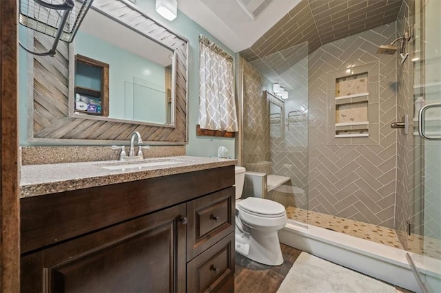 bathroom with toilet, a stall shower, and vanity