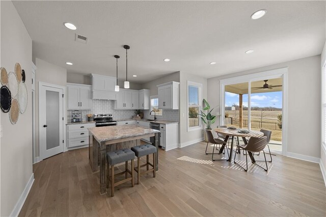 16967 S Hunter St, Olathe, KS 66062 - kitchen with visible vents, decorative backsplash, appliances with stainless steel finishes, a sink, and a kitchen island