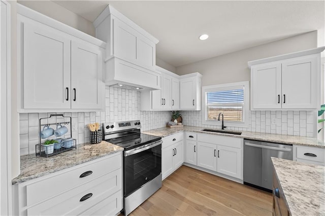 16967 S Hunter St, Olathe, KS 66062 - kitchen featuring light wood-style flooring, stainless steel appliances, a sink, white cabinetry, and custom exhaust hood