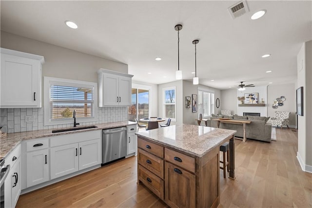 16967 S Hunter St, Olathe, KS 66062 - kitchen featuring stainless steel appliances, a fireplace, a sink, and white cabinetry