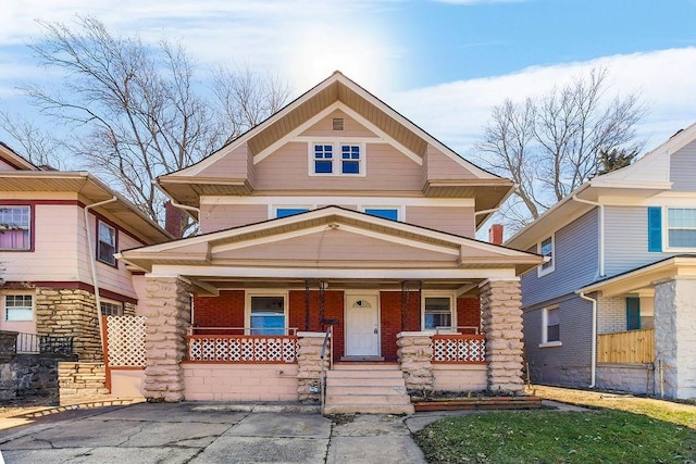 view of front of home with a porch and brick siding