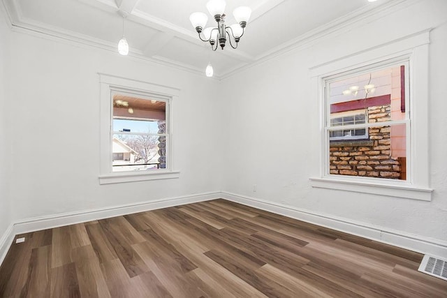 spare room with a chandelier, dark wood-type flooring, visible vents, and baseboards