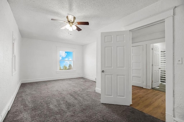 unfurnished bedroom with a textured ceiling, a textured wall, ceiling fan, carpet flooring, and baseboards