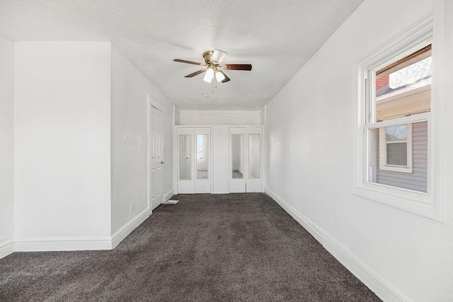 unfurnished room with ceiling fan, a textured ceiling, baseboards, and carpet flooring