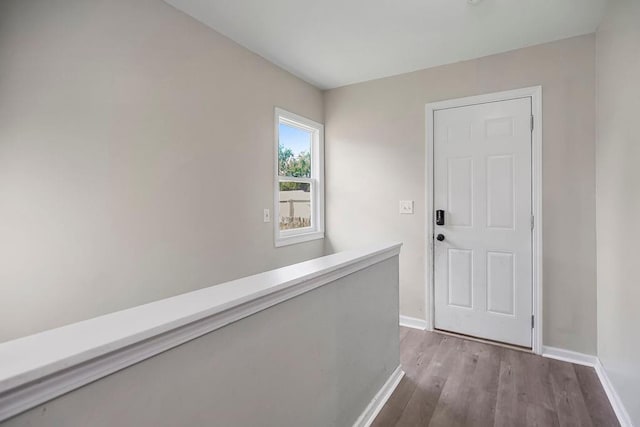 corridor with wood finished floors and baseboards