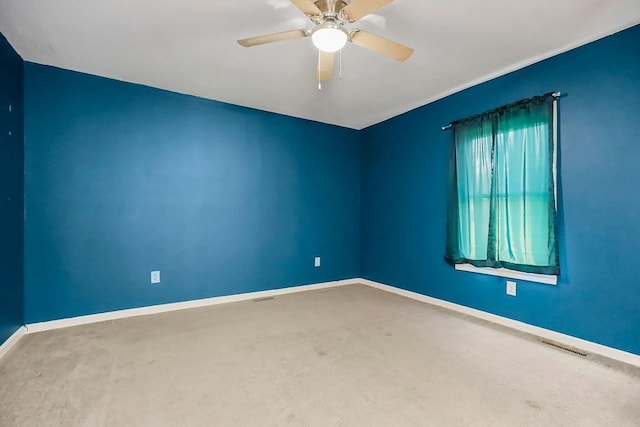 carpeted empty room with baseboards, visible vents, and a ceiling fan