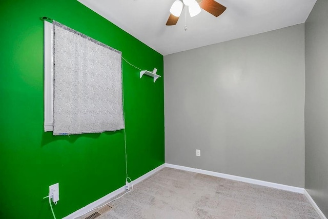 unfurnished room with baseboards, visible vents, and a ceiling fan