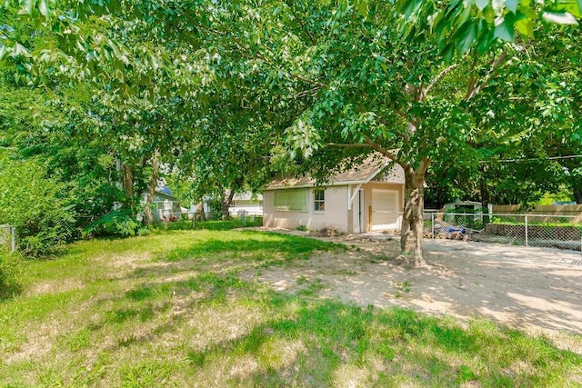 view of yard featuring fence, driveway, and an attached garage