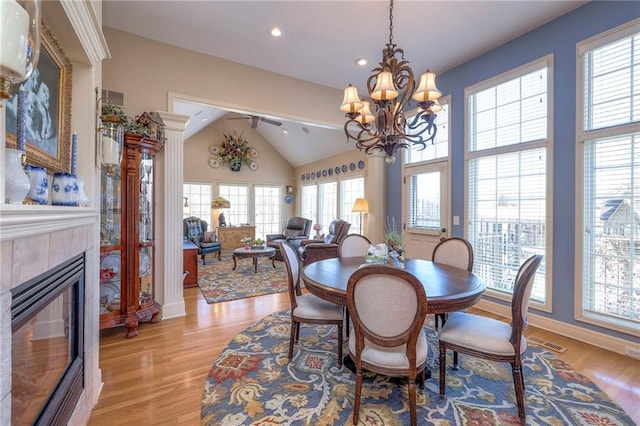 dining area featuring visible vents, lofted ceiling, light wood-style flooring, a fireplace, and recessed lighting