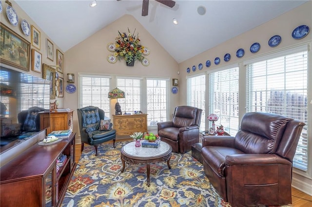 living area with high vaulted ceiling, a healthy amount of sunlight, and wood finished floors