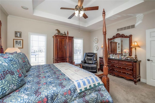 bedroom featuring ornamental molding, a raised ceiling, visible vents, and light colored carpet