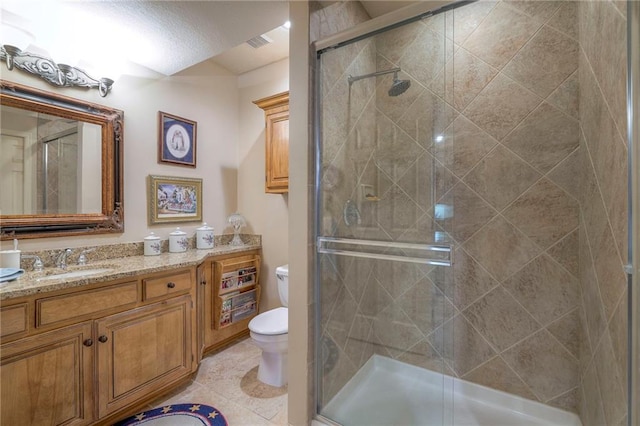 bathroom featuring a stall shower, visible vents, toilet, tile patterned flooring, and vanity