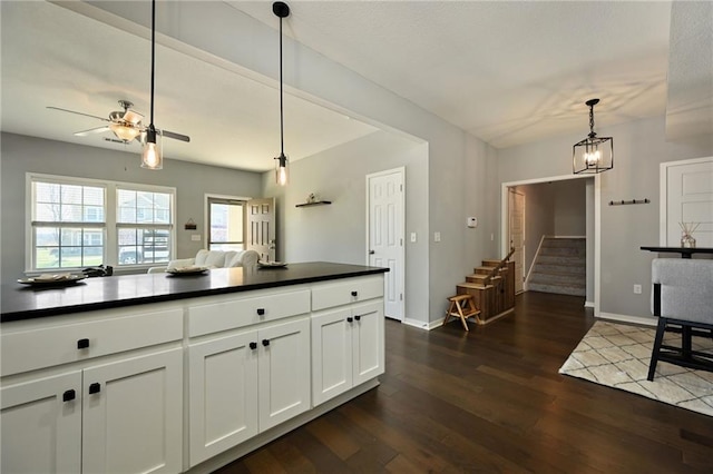 16059 Fontana St Unit 205, Overland Park, KS 66085 - kitchen featuring a ceiling fan, dark countertops, pendant lighting, and dark wood-style floors